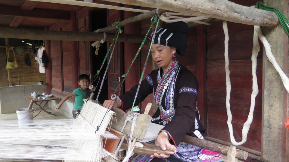Người phụ nữ Lự tận dung thời gian rảnh rỗi để dệt những bộ quần áo cho gia đình. (Ảnh: Việt Hoàng/TTXVN)