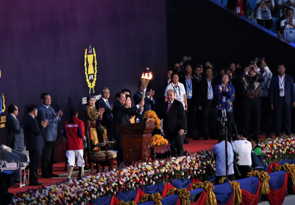 Ông Hun Many, đại diện Ủy ban Quốc gia tổ chức ASEAN Para Games 12 của Campuchia nhận ngọn đuốc từ một vận động viên khuyết tật và trao cho Thủ tướng Chính phủ Hoàng gia Campuchia Samdech Techo Hun Sen tại lễ đài Sân Vận động Quốc gia Morodok Techo. (Ảnh: Huỳnh Thảo/TTXVN)