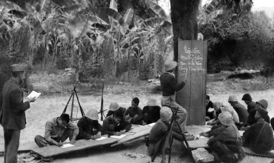 Lớp học “Diệt giặc dốt” cấp tốc của bộ đội và dân quân tự vệ trong giờ nghỉ trên thao trường trong kháng chiến chống Pháp. (Ảnh: TTXVN)