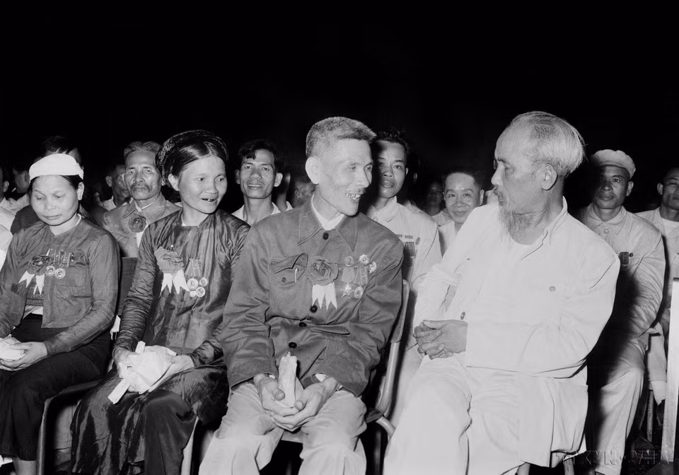 Chủ tịch Hồ Chí Minh nói chuyện thân mật với Anh hùng Lao động Nguyễn Phúc Đồng (Ngành Quân giới) và nữ Anh hùng Nguyễn Thị Năm (Dệt Nam Định) trong buổi họp mặt các đại biểu dự Đại hội liên hoan Anh hùng, Chiến sỹ thi đua Công-Nông-Binh toàn quốc lần thứ II (Hà Nội, 7/7/1958). (Ảnh: TTXVN)