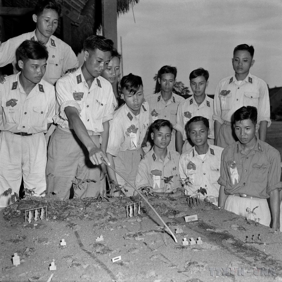 Hạ sỹ Phạm Ngọc Cương, lá cờ đầu trong phong trào thi đua “Chiến sỹ ba nhất” của đại đội 3 (Đoàn Vinh Quang) cùng các “Chiến sỹ ba nhất” ôn tập bài mục trên sa bàn thao trường. (Ảnh: Quang Thành/TTXVN)