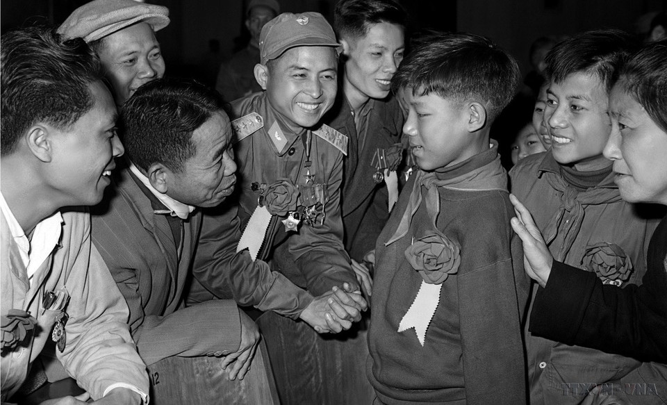 Các đại biểu tại Đại hội Anh hùng, Chiến sỹ thi đua toàn quốc lần thứ IV (1966) thăm hỏi em Hoa Xuân Tứ, học sinh lớp 6 (Nghệ An), bị cụt cả hai tay vẫn nỗ lực học tập, trở thành “Cháu ngoan Bác Hồ” và kiện tướng về thể dục. (Ảnh: TTXVN)
