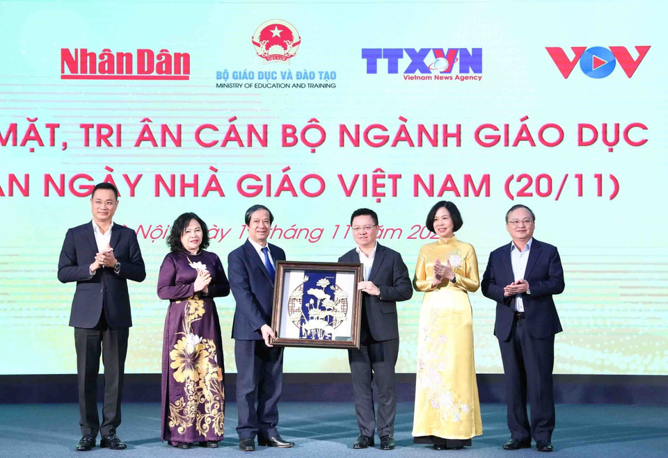 Ủy viên Trung ương Đảng, Tổng Biên tập Báo Nhân Dân, Chủ tịch Hội Nhà báo Việt Nam Lê Quốc Minh, đại diện lãnh đạo các cơ quan Thông tấn, báo chí tặng quà tri ân các nhà giáo. (Ảnh: Minh Đức/TTXVN)
