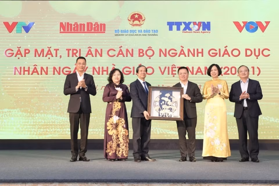 Ủy viên Trung ương Đảng, Tổng Biên tập Báo Nhân Dân, Chủ tịch Hội Nhà báo Việt Nam Lê Quốc Minh, đại diện lãnh đạo các cơ quan Thông tấn, báo chí tặng quà tri ân các nhà giáo. (Ảnh: Minh Quyết/TTXVN)