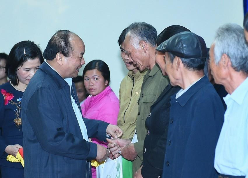 Thủ tướng Nguyễn Xuân Phúc thăm hỏi, tặng quà các hộ gia đình chính sách, có hoàn cảnh khó khăn của huyện Trà Lĩnh trong chuyến công tác tỉnh Cao Bằng, ngày 8/1/2017. (Ảnh: Thống Nhất/TTXVN)