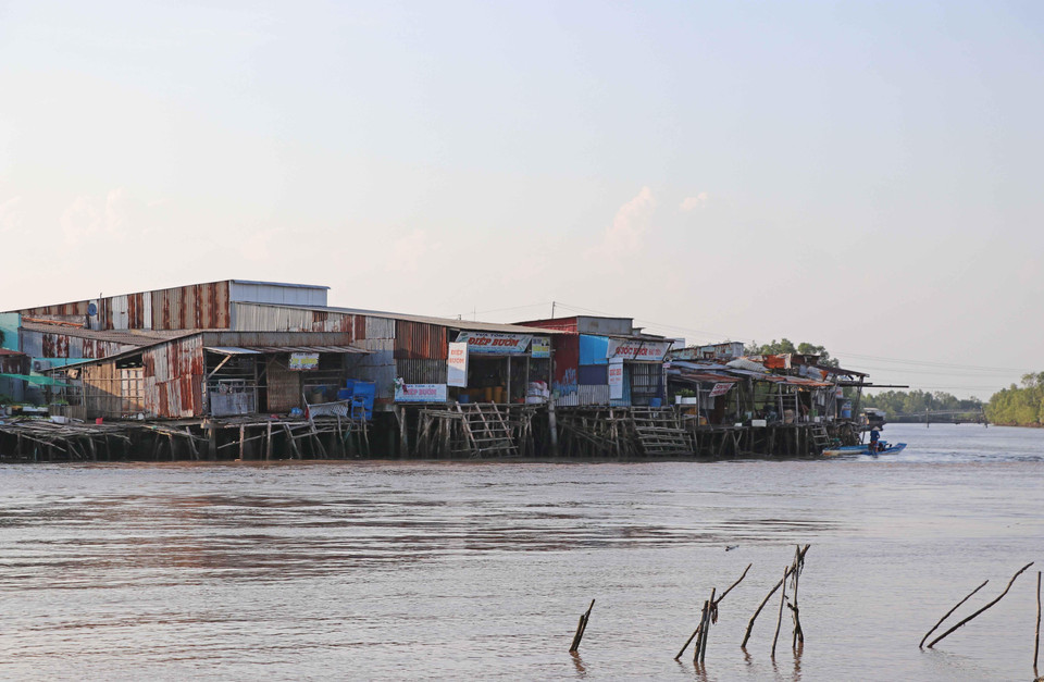 Tập quán sinh sống ven sông của người dân rất khó thay đổi, dù hiểm họa sạt lở đang rình rập từng ngày. (Ảnh: Thế Anh/TTXVN)