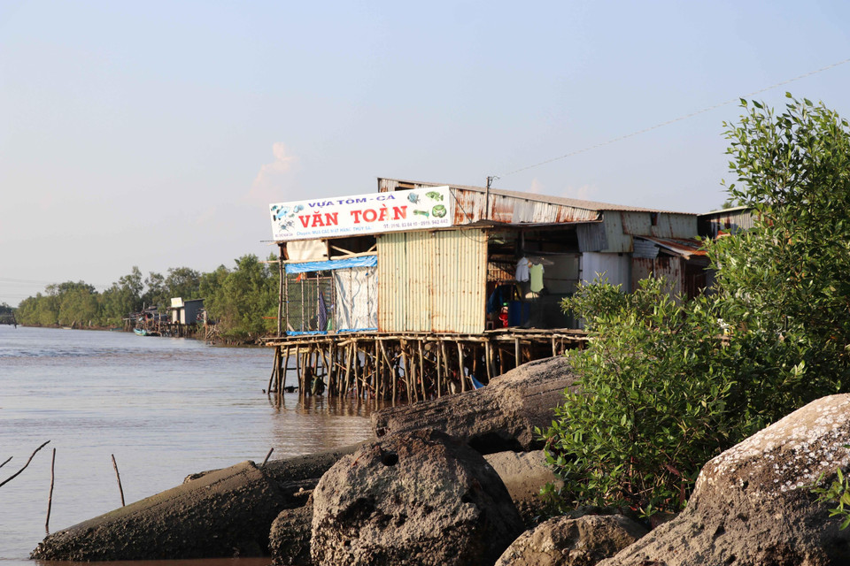 Tập quán sinh sống ven sông của người dân rất khó thay đổi, dù hiểm họa sạt lở đang rình rập từng ngày. (Ảnh: Thế Anh/TTXVN)