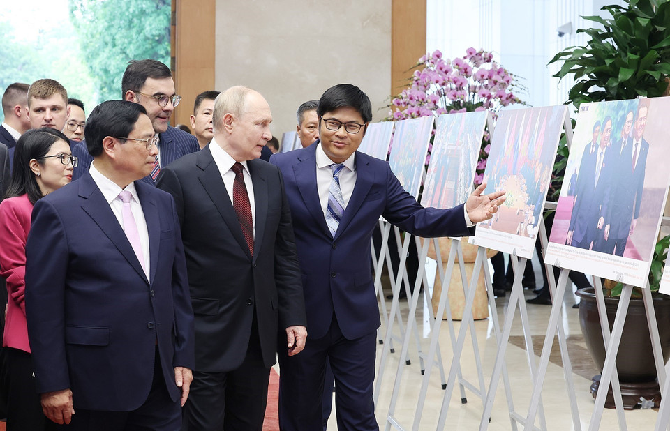 Thủ tướng Phạm Minh Chính và Tổng thống Liên bang Nga Vladimir Putin xem trưng bày ảnh về quan hệ hợp tác giữa hai nước do Thông tấn xã Việt Nam thực hiện (Hà Nội, chiều 20/6/2024). (Ảnh: Dương Giang/TTXVN)
