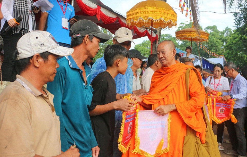 Ban tổ chức trao cờ lưu niệm cho các chủ bò tham gia Hội đua bò Chùa Rô lần thứ X năm 2024. (Ảnh: Công Mạo/TTXVN)