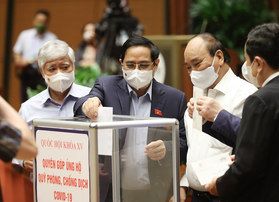 Chủ tịch nước Nguyễn Xuân Phúc, Thủ tướng Phạm Minh Chính và các đại biểu Quốc hội quyên góp ủng hộ Quỹ phòng, chống dịch COVID-19. (Ảnh: Dương Giang/TTXVN)