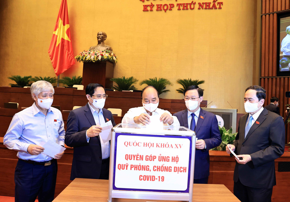 Chủ tịch nước Nguyễn Xuân Phúc, Thủ tướng Phạm Minh Chính, Chủ tịch Quốc hội Vương Đình Huệ và các đại biểu Quốc hội quyên góp ủng hộ Quỹ phòng chống dịch COVID-19. (Ảnh: Thống Nhất/TTXVN)