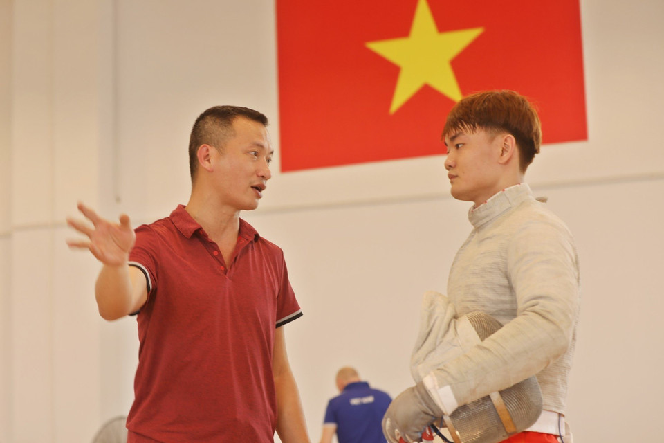 Huấn luyện viên Phạm Anh Tuấn chia sẻ, truyền thụ kinh nghiệm, kỹ năng trong những tình huống cụ thể trong buổi tập của đội tuyển Đấu kiếm Việt Nam. ( Ảnh: Minh Quyết/TTXVN)