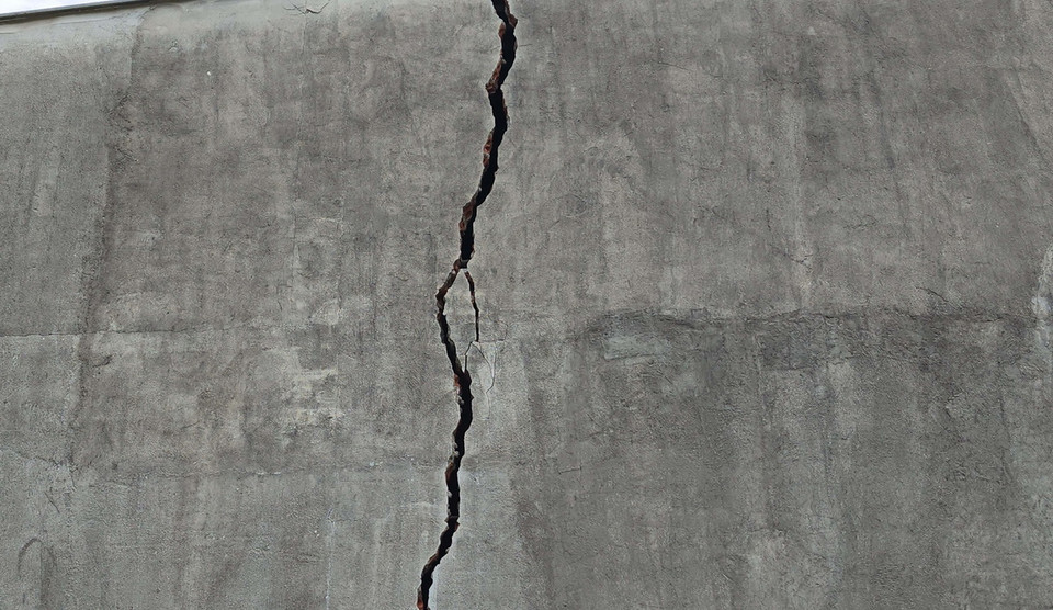 Suối Bưng Hổ sạt lở làm nứt toác nhà dân. (Ảnh: Đậu Tất Thành/TTXVN)