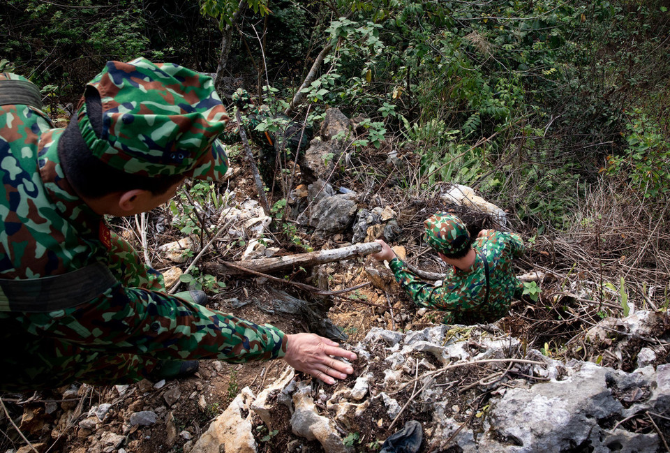 Địa hình hiểm trở gây nhiều khó khăn trong quá trình di chuyển nhưng không thể lay chuyển mong muốn tìm kiếm, đưa đồng đội về sớm nhất của Đội tìm kiếm quy tập hài cốt liệt sỹ Hà Giang. (Ảnh: Hoàng Hiếu/TTXVN)