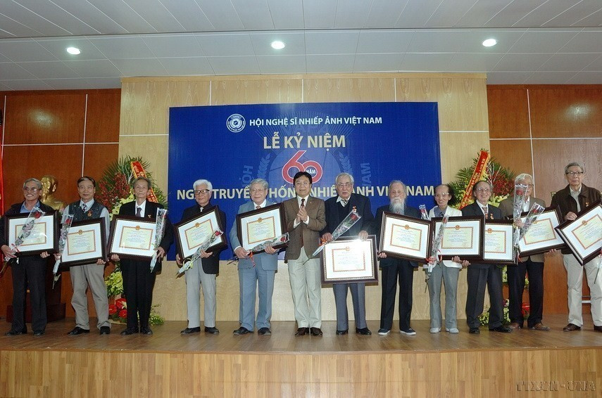 Thứ trưởng Bộ Văn hóa, Thể thao và Du lịch Vương Duy Biên trao tặng Kỷ niệm chương Vì sự nghiệp Văn hoá, Thể thao và Du lịch” cho các nghệ sỹ nhiếp ảnh có nhiều đóng góp tích cực cho ngành Nhiếp ảnh Việt Nam tại Lễ kỷ niệm 60 năm Ngày Truyền thống Nhiếp ảnh Việt Nam (2013). (Ảnh: Minh Đức/TTXVN)