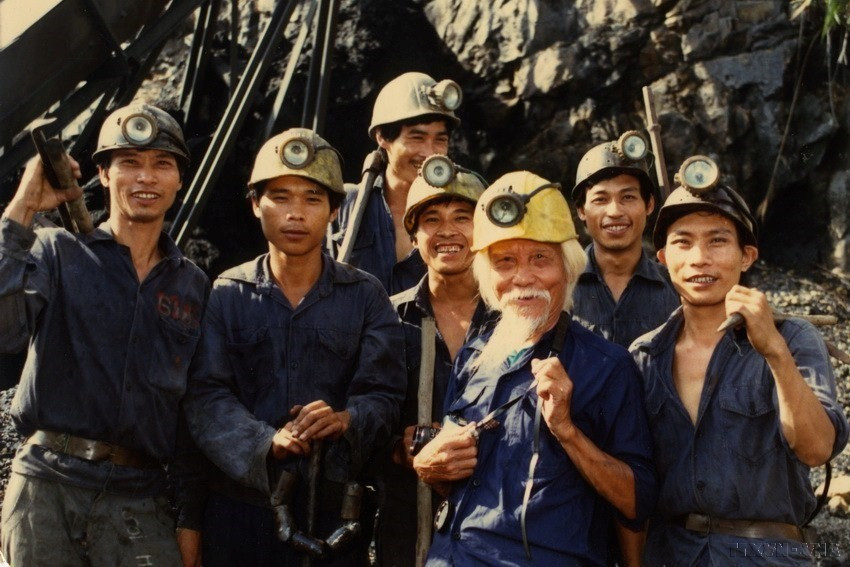 Nghệ sỹ nhiếp ảnh Võ An Ninh (đội mũ vàng) chụp ảnh chung với công nhân khai thác mỏ than Quảng Ninh trong những năm chống chiến tranh phá hoại của Mỹ ở miền Bắc. (Ảnh: Minh Lộc/TTXVN)