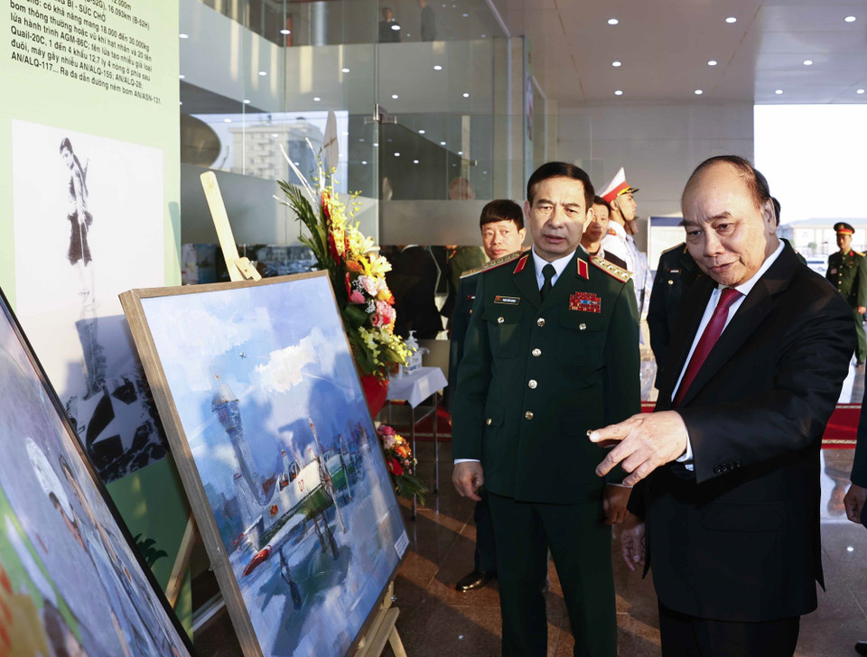 Chủ tịch nước Nguyễn Xuân Phúc và các đại biểu xem các bức tranh trưng bày tại buổi gặp mặt. (Ảnh: Thống Nhất/TTXVN)