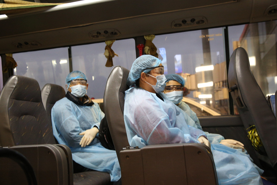 Các công dân Việt Nam về nước và được đưa lên xe. (Ảnh: Dương Giang/TTXVN)