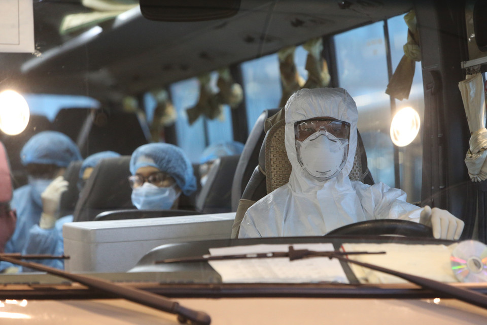 Xe đưa các công dân Việt Nam rời sân bay Vân Đồn đến khu vực cách ly để theo dõi và điều trị. (Ảnh: Dương Giang/TTXVN)