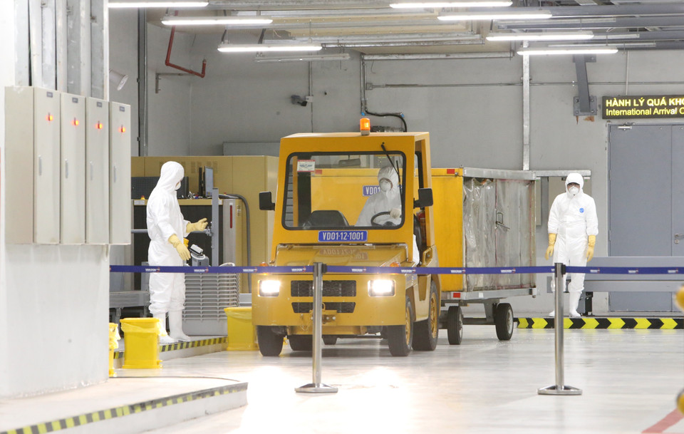 Hành lý ký gửi được tẩy trùng và đưa vào khu vực cách ly. (Ảnh: Dương Giang/TTXVN)