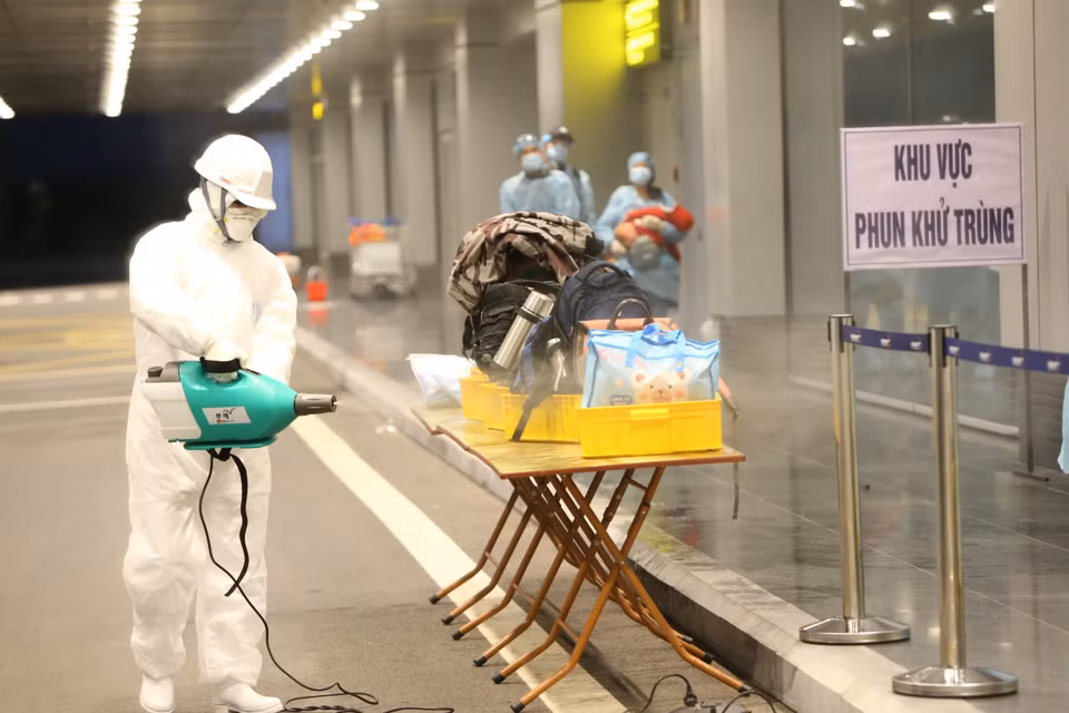 Phun hoá chất khử trùng hành lý của cho công dân Việt Nam trở về từ Vũ Hán (Trung Quốc). (Ảnh: Dương Giang/TTXVN)