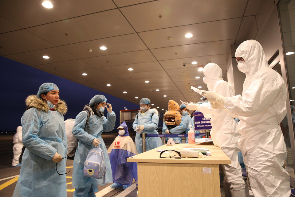 Nhân viên Cảng hàng không sân bay Vân Đồn làm thủ tục nhập cảnh cho công dân Việt Nam trở về từ Vũ Hán (Trung Quốc). (Ảnh: Dương Giang/TTXVN)