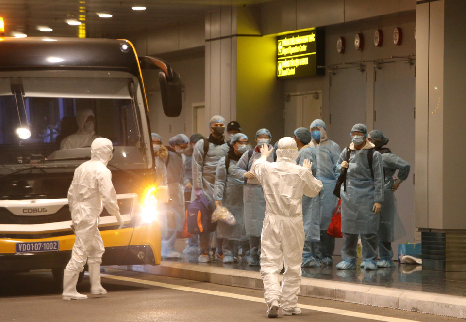 Lực lượng chức năng tại hiện trường hướng dẫn các công dân kiểm tra y tế và làm thủ tục nhập cảnh. (Ảnh: Dương Giang/TTXVN)