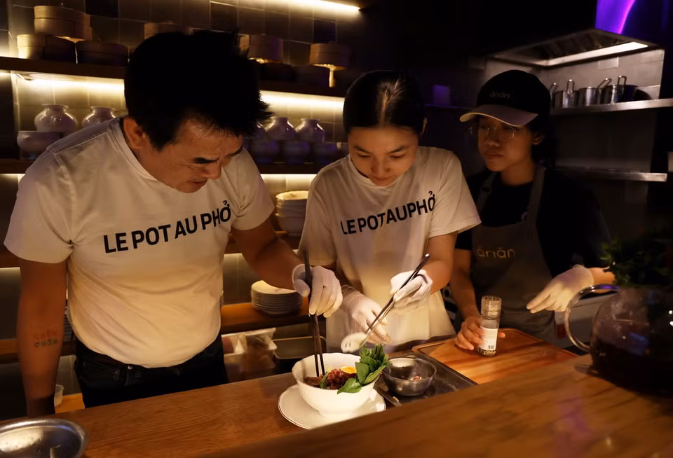 Các đầu bếp nhà hàng Pot Au Phở chuẩn bị một tô phở đặc biệt cho thực khách. (Ảnh: Hồng Đạt/TTXVN)