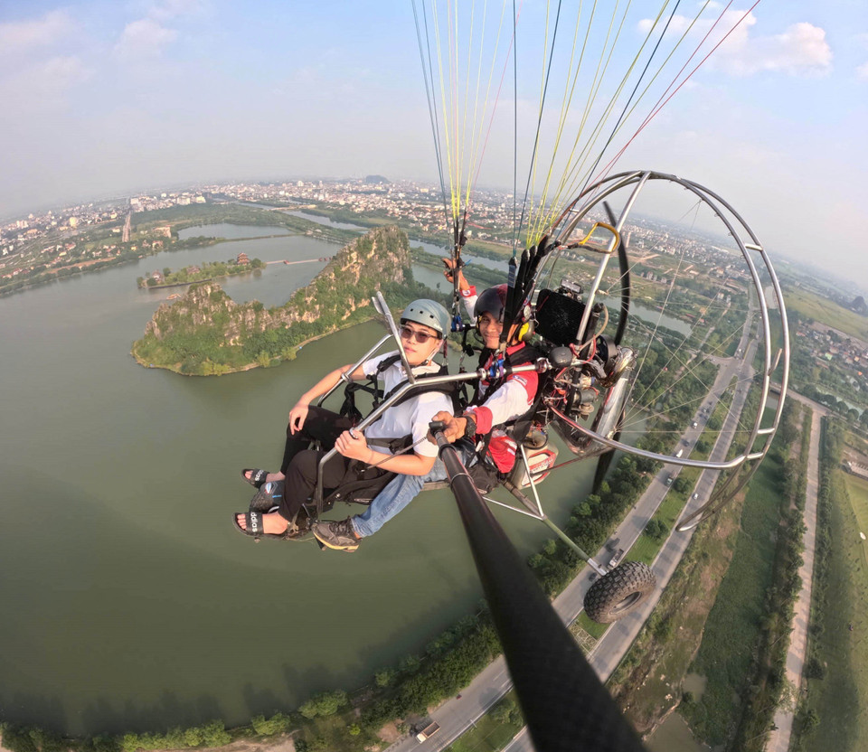 Du khách trải nghiệm bộ môn dù lượn tại Ninh Bình. (Ảnh: Thùy Dung/TTXVN)