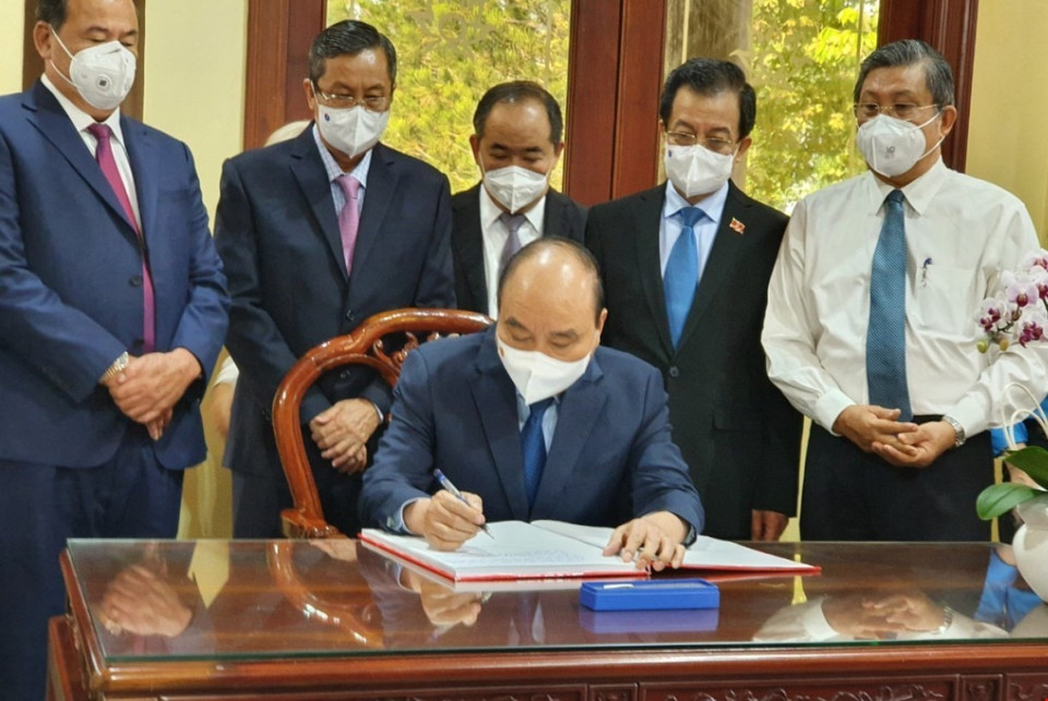 Chủ tịch nước Nguyễn Xuân Phúc viết cảm tưởng vào Sổ vàng tại Khu lưu niệm Chủ tịch Tôn Đức Thắng. (Ảnh: TTXVN phát)