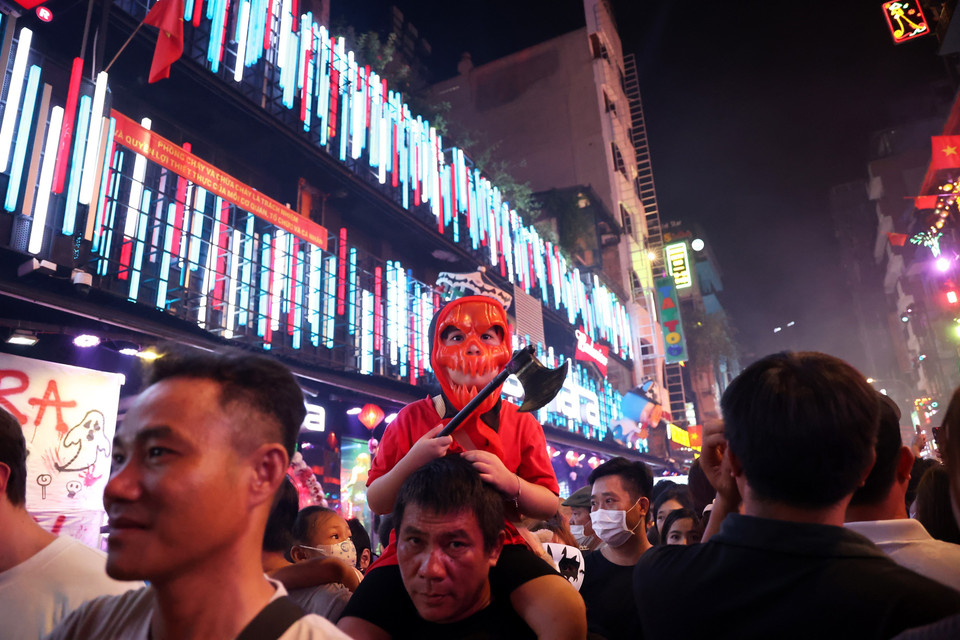 Một em nhỏ đeo mặt nạ và cầm chiếc rìu của quỷ trong đêm Halloween. (Ảnh: Hồng Đạt/TTXVN)