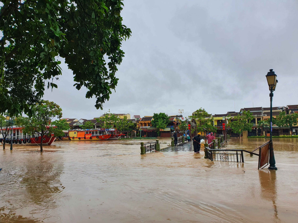 Các lực lượng tại chỗ đang vớt rác mắc kẹt dưới cầu An Hội để khơi thông dòng chảy. (Ảnh: Hữu Trung/TTXVN)