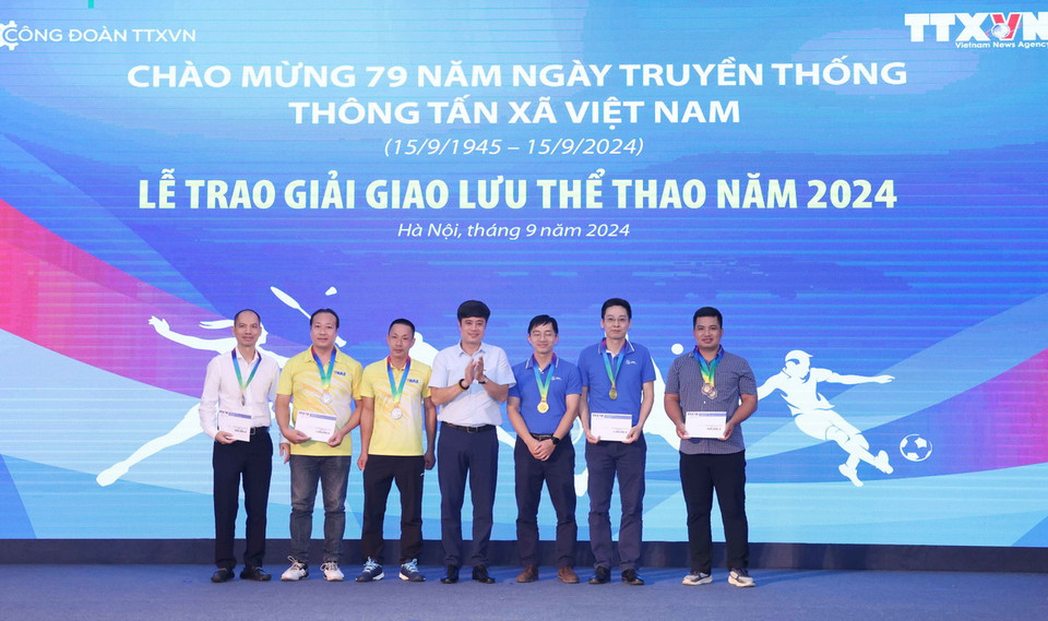Trưởng Ban Tài chính Công đoàn TTXVN Nguyễn Tiến Dũng trao giải môn Cầu lông đôi nam cho các vận động viên. (Ảnh: Phương Hoa/TTXVN)