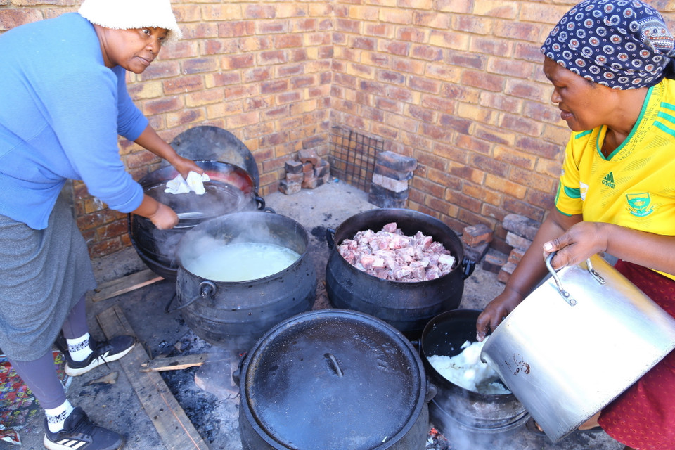 Những người phụ nữ của bộ tộc tất bật nấu ăn chuẩn bị cho buổi lễ đăng quang. (Ảnh: Hồng Minh/TTXVN)