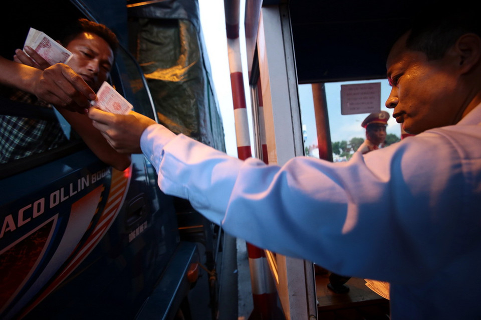 Lái xe cố tình chậm chạp trả từng đồng tiền lẻ tại trạm thu phí BOT số 1 quốc lộ 5 huyện Văn Lâm. (Ảnh: Phạm Kiên/TTXVN)