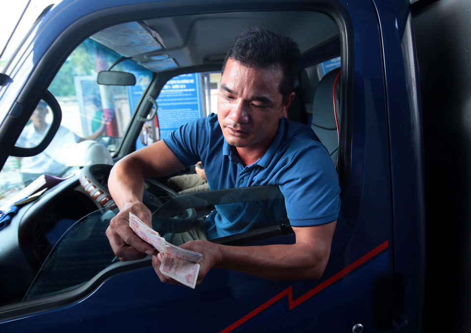 Lái xe cố tình chậm chạp trả từng đồng tiền lẻ tại trạm thu phí BOT số 1 quốc lộ 5 huyện Văn Lâm. (Ảnh: Phạm Kiên/TTXVN)