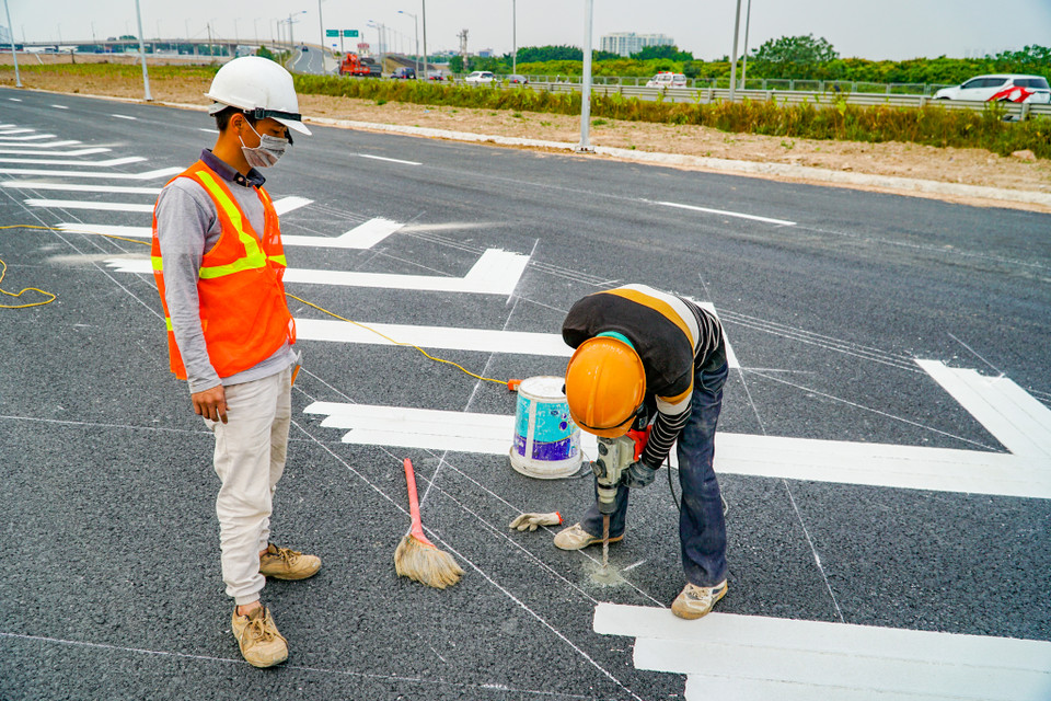 Khoan lỗ bề mặt đường để lắp đinh phản quang. (Ảnh: Minh Hiếu/Vietnam+)