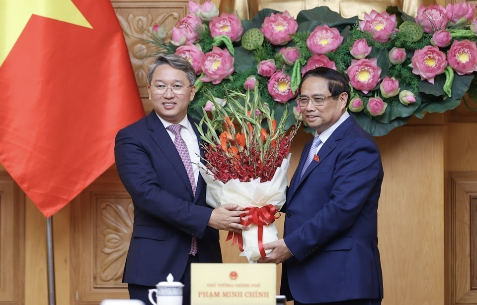 Thủ tướng Phạm Minh Chính tặng hoa chúc mừng tân Bộ trưởng Bộ Tư pháp Nguyễn Hải Ninh. (Ảnh: Dương Giang/TTXVN)