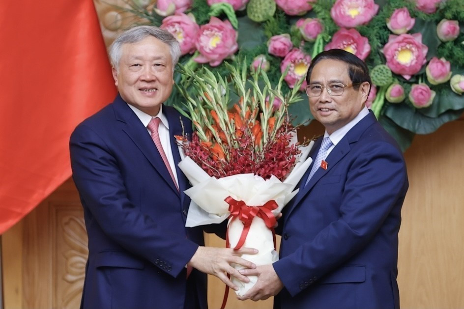 Thủ tướng Phạm Minh Chính tặng hoa chúc mừng tân Phó Thủ tướng Nguyễn Hoà Bình. (Ảnh: Dương Giang/TTXVN)