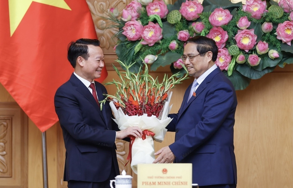 Thủ tướng Phạm Minh Chính tặng hoa chúc mừng tân Bộ trưởng Bộ Tài nguyên và Môi trường Đỗ Đức Duy. (Ảnh: Dương Giang/TTXVN)