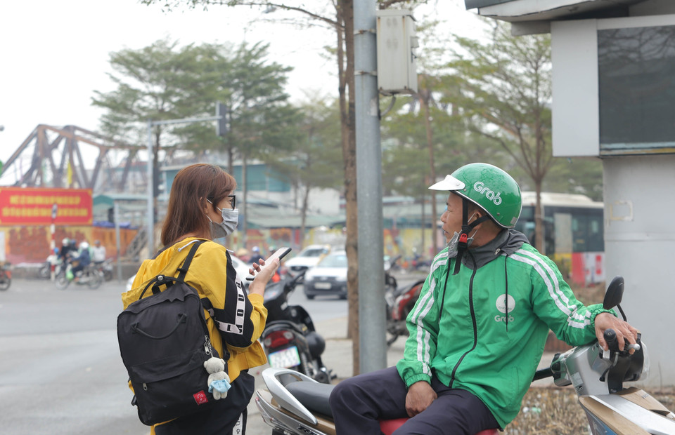 Một lái xe công nghệ không đeo khẩu trang đúng quy cách tại Bến xe buýt Long Biên. (Ảnh: Hoàng Hiếu/TTXVN)