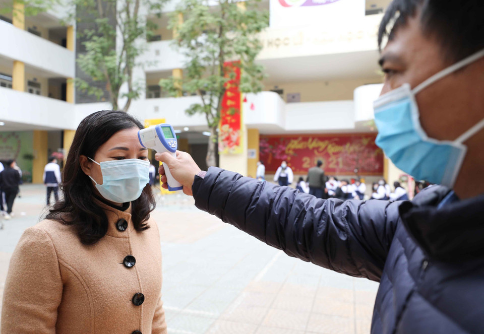 Trường THPT Trần Nhân Tông, quận Hai Bà Trưng (Hà Nội) thực hiện đo thân nhiệt, sát khuẩn tay cho cán bộ, giáo viên và học sinh mỗi khi ra, vào trường (ảnh chụp sáng 29/1). (Ảnh: Thanh Tùng/TTXVN)