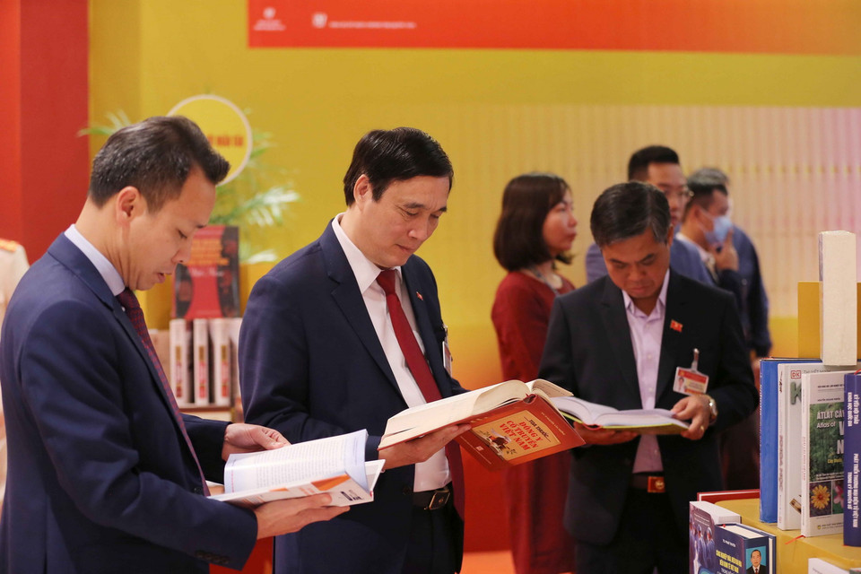 Đại biểu xem các cuốn sách tiêu biểu tại không gian trưng bày sách, báo phục vụ Đại hội XIII. (Ảnh: TTXVN)