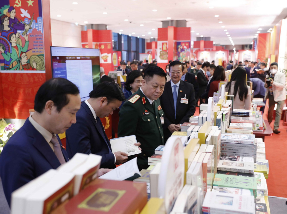 Đại biểu xem các cuốn sách tiêu biểu tại không gian trưng bày sách, báo phục vụ Đại hội XIII. (Ảnh: TTXVN)
