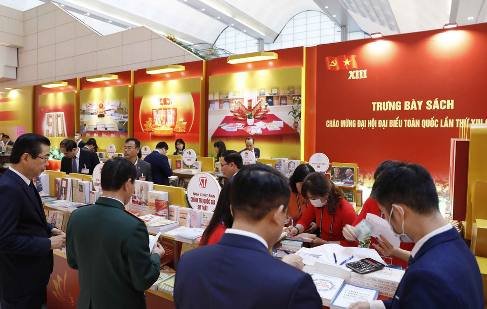 Đại biểu xem các cuốn sách tiêu biểu tại không gian trưng bày sách, báo phục vụ Đại hội XIII. (Ảnh: TTXVN)