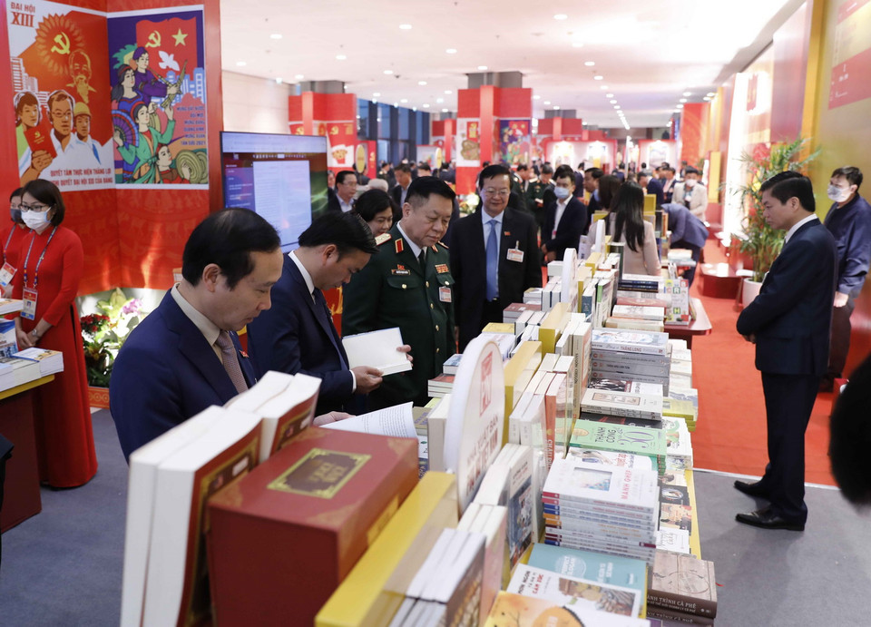 Đại biểu xem các cuốn sách tiêu biểu tại không gian trưng bày sách, báo phục vụ Đại hội XIII. (Ảnh: TTXVN)