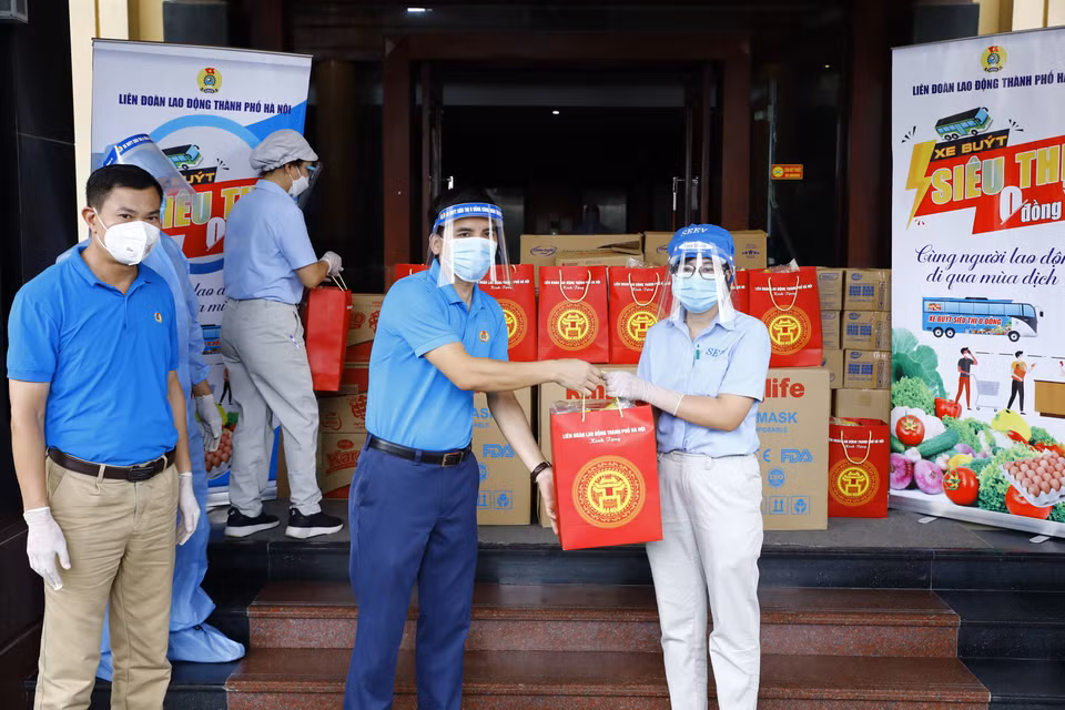 Phó Chủ tịch Liên đoàn Lao động thành phố Hà Nội Lê Đình Hùng trao quà cho công nhân đang cách ly tại khách sạn Hà Anh. (Ảnh: Minh Đức/TTXVN)