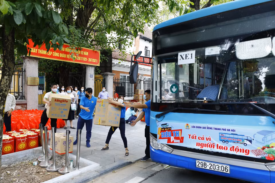Cán bộ, nhân viên Liên đoàn Lao động thành phố Hà Nội vận chuyển hàng lên xe buýt siêu thị 0 đồng. (Ảnh: Minh Đức/TTXVN)