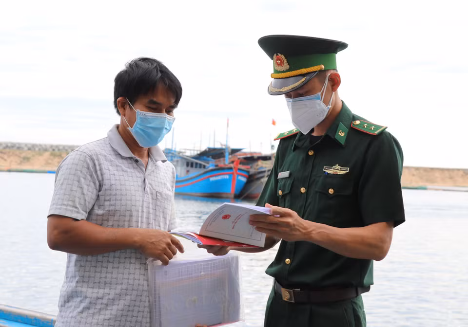 Thành viên Tổ phòng chống dịch Đồn biên phòng Hòa Hiệp Nam kiểm tra tàu cá PY94544TS do ông Đặng Văn Cường làm thuyền trưởng. (Ảnh: Phạm Cường/TTXVN)