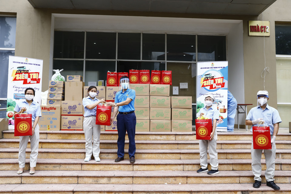 Phó Chủ tịch Liên đoàn Lao động thành phố Hà Nội Lê Đình Hùng trao quà cho công nhân lao động Công ty TNHH Linh kiện điện tử SEI. (Ảnh: Minh Đức/TTXVN)